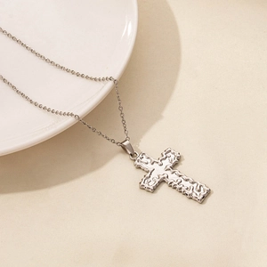 Detail of silver cross pendant with molten lava texture on minimalist chain link