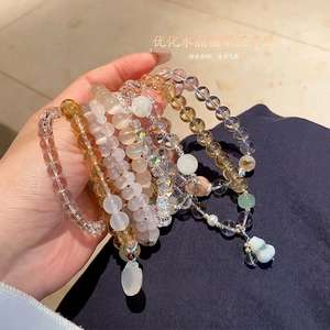 Handheld photo showing natural chalcedony and quartz crystal beaded bracelets with charm