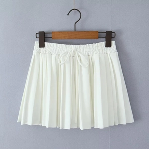 Detail of high waisted white pleated skirt with decorative drawstring on a wooden hanger