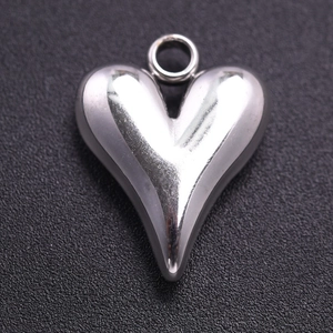 Macro view of a silver heart-shaped pendant with a polished stainless steel finish