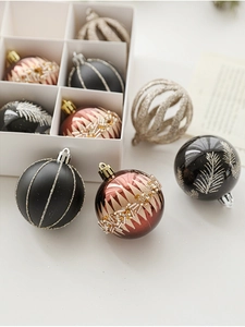 Detail view of various 6cm Christmas balls with glitter and patterns in a display box