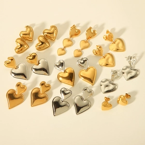 Detailed grid of 18K gold and silver heart-shaped stud and drop earrings