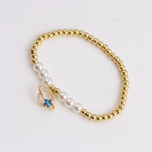 Chic gold beaded bracelet with white pearls and blue star planet pendant on white background