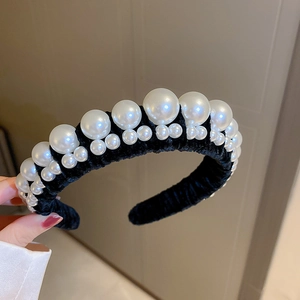 Close-up of vintage black velvet headband with elegant pearls and tiered high crown design