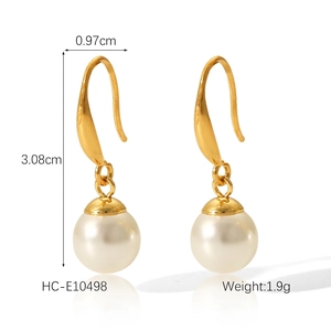 Détail des boucles d'oreilles en acier doré avec perles blanches et mesure de 3,08 cm de haut