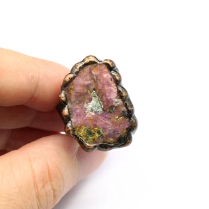 Macro shot of natural pink agate geode ring with green inclusions and bronze band