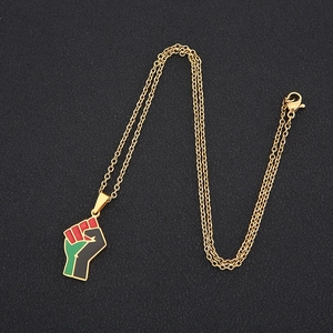 Detail of gold-plated fist pendant with red green black enamel on a cable chain
