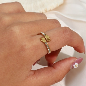 Golden hug ring with sparkling cubic zirconia on white silk background