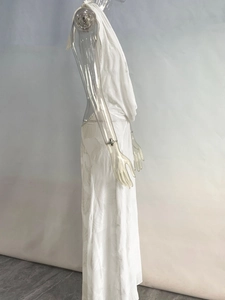 Detail of white deep V-neck halter maxi dress with intricate leaf jacquard pattern