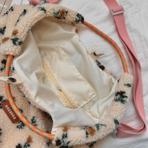Detail view of the warm fleece tote bag showing soft cream lining and interior zipper pocket