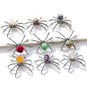 Handcrafted spider ornaments featuring various natural crystal stones on a clean white background