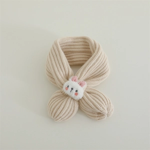 Detail of knitted beige baby scarf featuring a soft plush bunny patch and cross design