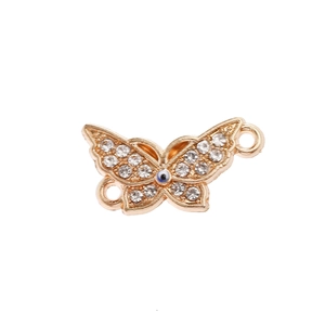 Macro detail of gold butterfly evil eye pendant connector with white rhinestones