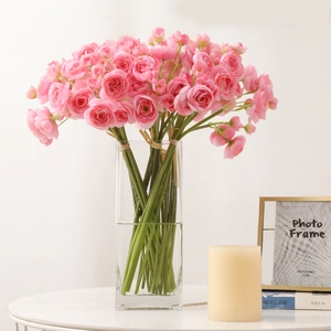 Pink artificial camellia silk flowers in a clear glass vase for elegant home table decor