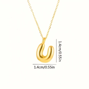 Dettaglio macro del ciondolo a lettera U a palloncino dorato da 1,4 cm con finitura lucida