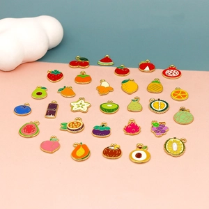 Detailed flat lay of twenty-eight mini fruit enamel alloy charms on a colorful background