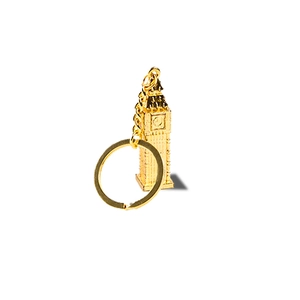Golden Big Ben clock tower keychain souvenir crafted from polished metal on white background