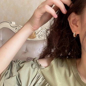 Detail of elegant gold double-row rhinestone hoop earrings on female model