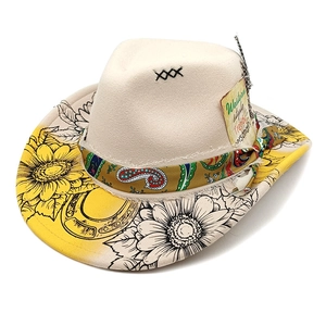 Détail d'un chapeau de cowboy en feutre avec fleurs de tournesol, bandana et plume