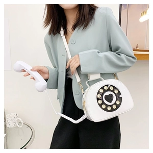 Creative white vintage telephone cross-body bag featuring a realistic dial and handset