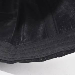 Dettaglio delle cuciture multiple su tessuto nero per falda di cappello con strass