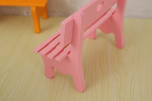 Detail of pink wooden miniature park bench with heart cutout for micro landscape decor