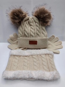 Three-piece beige knit winter set featuring a double pom-pom beanie, scarf, and gloves