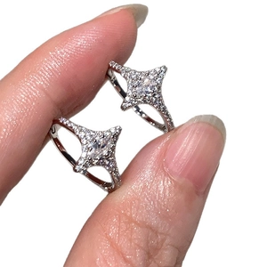 Elegant silver star earrings with zircons shown being held to demonstrate scale
