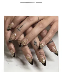 Gros plan d'ongles amande avec pointes French noires et relief doré 3D artistique