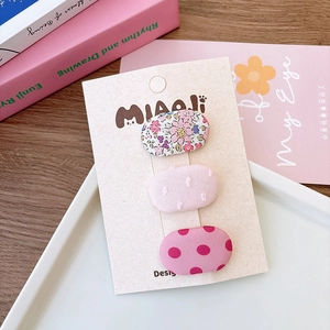 Set di tre fermagli per capelli in tessuto floreale per bambine su carta da esposizione