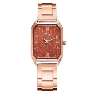 Detailed close-up of a rose gold octagonal square watch with a brown brushed dial