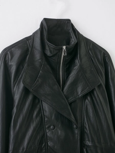 Detail view of the layered collar design and silver zipper on black leather jacket