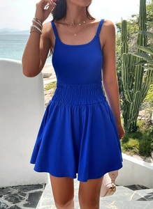 Blue A-line summer dress with thin straps and elastic high waist on a beach background
