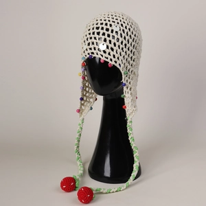 Detailed close-up of crochet knit hat with colorful beads and strawberry tassels