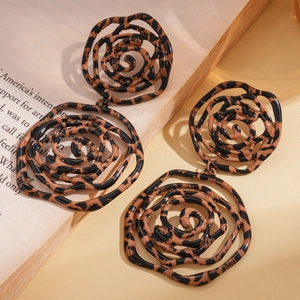 Retro oversized leopard print rose flower earrings with layered petals on a vintage book