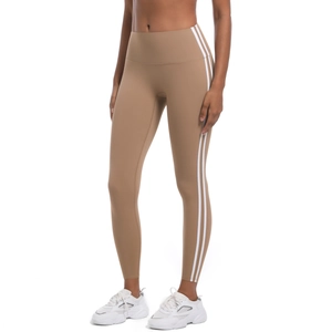 Détail du legging de yoga taille haute en camel clair avec rayures blanches latérales