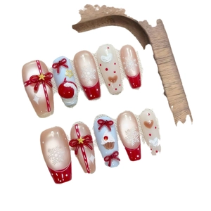 Christmas themed press-on nails with red bows, snowflakes and long trapezoidal design