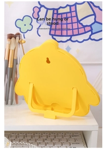 Detail of cartoon yellow makeup mirror showing the folding stand and hanging hole feature