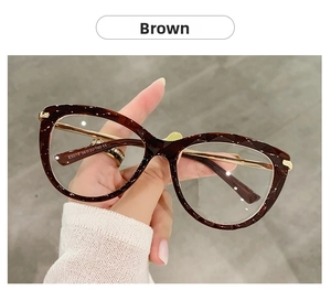 Dettaglio degli occhiali cat-eye tartarugati con stanghette in metallo dorato e logo CE