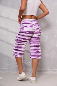 Detail of purple and white tie-dye denim shorts featuring back pockets and raw hems