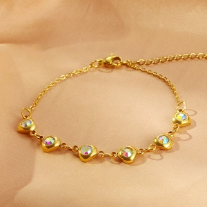 Elegant gold stainless steel bracelet with iridescent zircon heart charms on satin