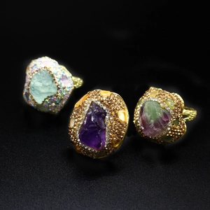 Macro detail of three vintage gold rings featuring amethyst and raw stones with rhinestones