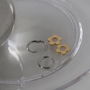 Daisy flower earrings in gold and silver contrast stainless steel with a minimalist hoop design