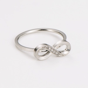 Macro shot of silver infinity ring with sparkling pavé-set crystals on white background