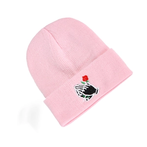 Close-up of pink knit beanie featuring detailed red rose embroidery on the folded cuff