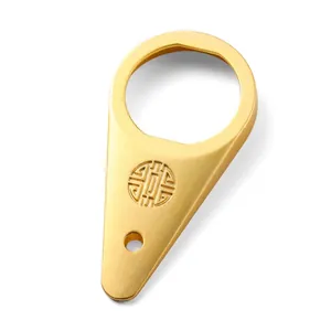 Macro detail of golden teardrop bottle opener with refined circular embossed texture