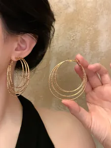 Detailed view of layered golden geometric hoop earrings with textured metallic finish