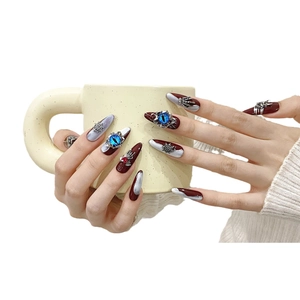 Handmade Gothic press-on nails in long almond shape with dark red marbling and 3D spider charms