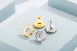 Detail of gold and silver ring earrings with white mother-of-pearl and pavé crystals
