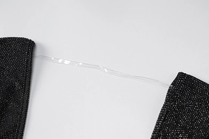 Close-up of black sparkly fabric with silver glitter and clear silicone shoulder strap